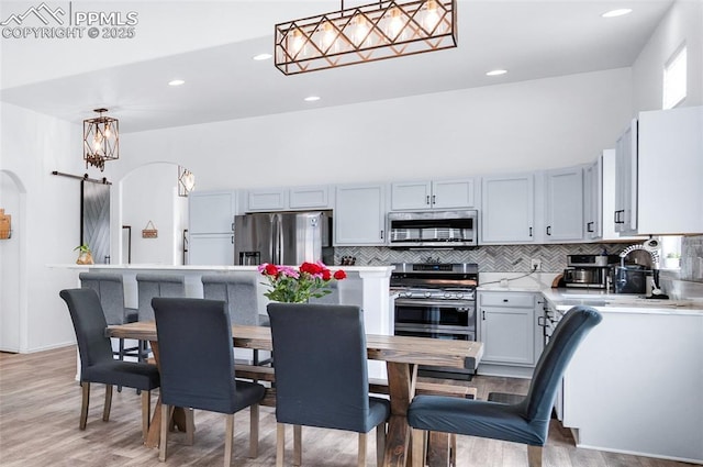 6244 Roundup Butte St, Colorado Springs, CO 80925 - kitchen featuring appliances with stainless steel finishes, light countertops, decorative backsplash, light wood-style floors, and recessed lighting