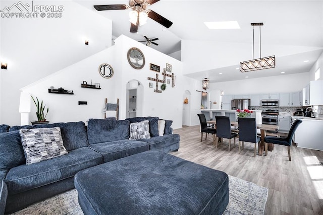 6244 Roundup Butte St, Colorado Springs, CO 80925 - living room featuring arched walkways, a ceiling fan, light wood finished floors, and high vaulted ceiling