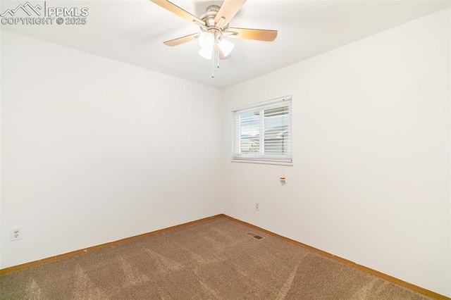 carpeted spare room featuring baseboards and ceiling fan