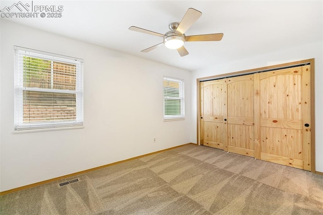 unfurnished bedroom with carpet floors, baseboards, and multiple windows