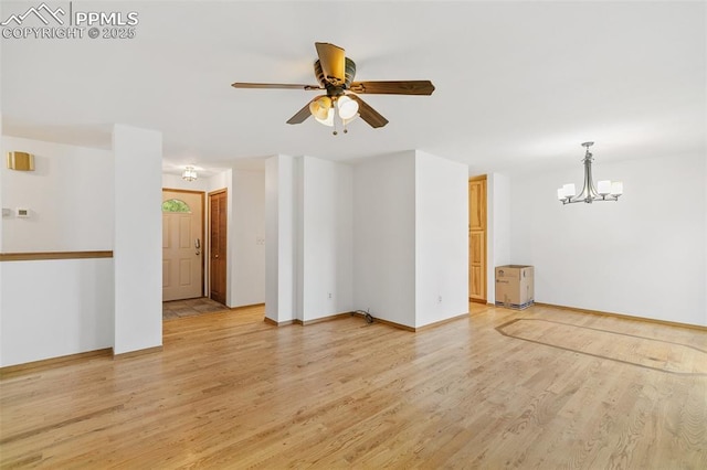 unfurnished room featuring light wood-type flooring, a chandelier, a ceiling fan, and baseboards