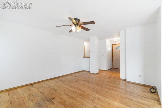 spare room featuring a ceiling fan, light wood finished floors, and baseboards