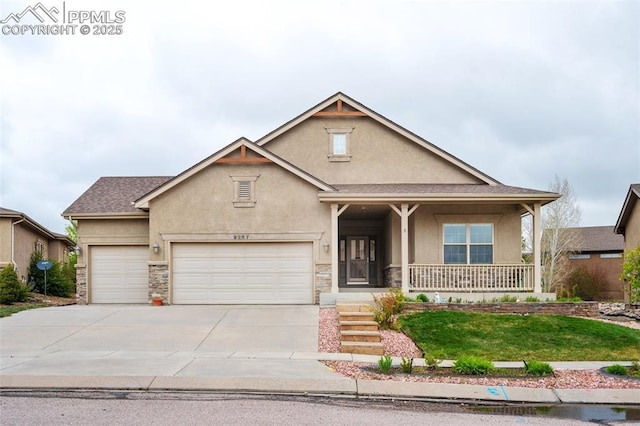 view of front of house with stucco siding, a garage, covered porch, driveway, and stone siding