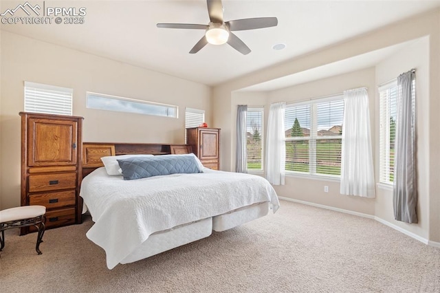carpeted bedroom with multiple windows, baseboards, and a ceiling fan