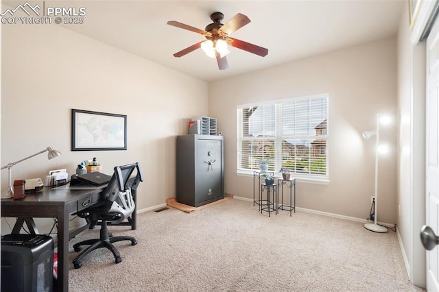 carpeted office space featuring ceiling fan and baseboards