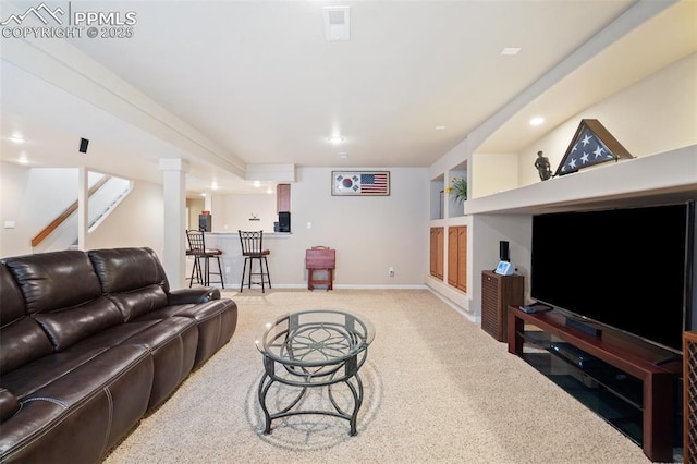 carpeted living room with bar and baseboards