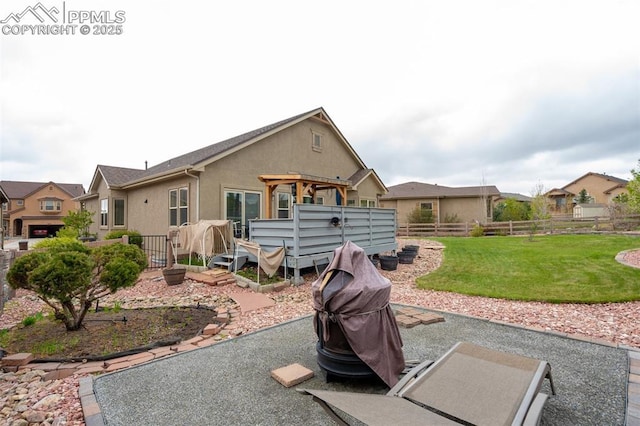 rear view of property with a jacuzzi, stucco siding, a pergola, and a patio