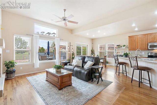 living room with ceiling fan, light wood finished floors, recessed lighting, and baseboards