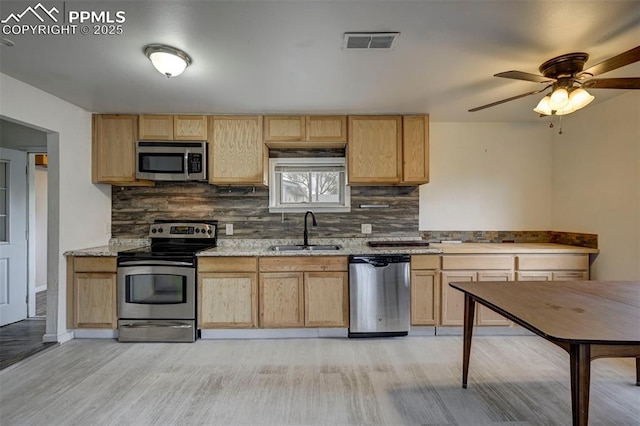 505 2nd Ave, Deer Trail, CO 80105 - kitchen featuring appliances with stainless steel finishes, a sink, light brown cabinetry, and decorative backsplash