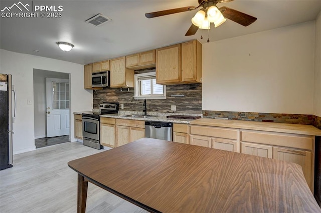 505 2nd Ave, Deer Trail, CO 80105 - kitchen featuring stainless steel appliances, light brown cabinets, a sink, tasteful backsplash, and light countertops