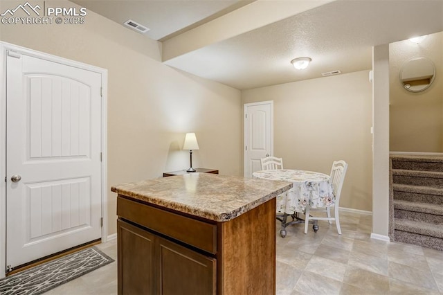 7567 Black Spruce Hts, Colorado Springs, CO 80908 - kitchen with a center island, baseboards, and light countertops
