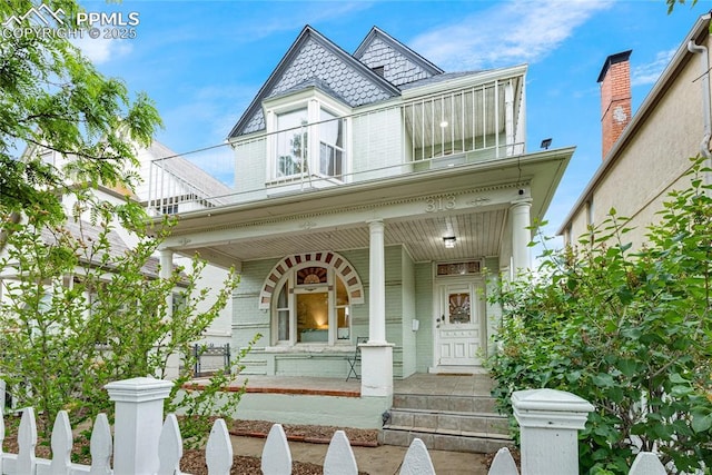 313 E Evans Ave, Pueblo, CO 81004 - victorian home featuring a porch, a balcony, and brick siding