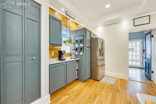 313 E Evans Ave, Pueblo, CO 81004 - kitchen featuring stainless steel fridge with ice dispenser, light wood-type flooring, baseboards, light countertops, and a raised ceiling