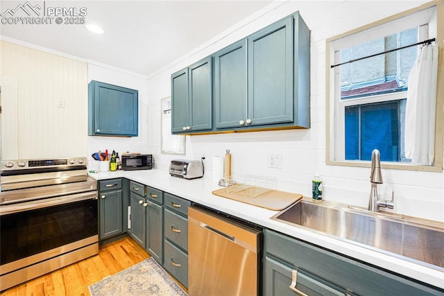 313 E Evans Ave, Pueblo, CO 81004 - kitchen featuring appliances with stainless steel finishes, a sink, crown molding, light countertops, and light wood-style floors