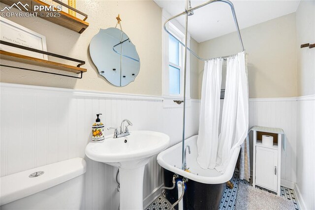 313 E Evans Ave, Pueblo, CO 81004 - full bath with wainscoting, toilet, a tub, a shower with shower curtain, and a sink