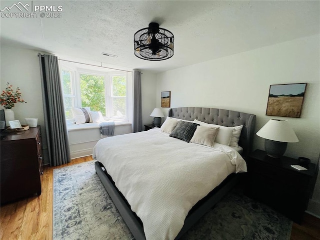 313 E Evans Ave, Pueblo, CO 81004 - bedroom featuring wood finished floors, a chandelier, and a textured ceiling