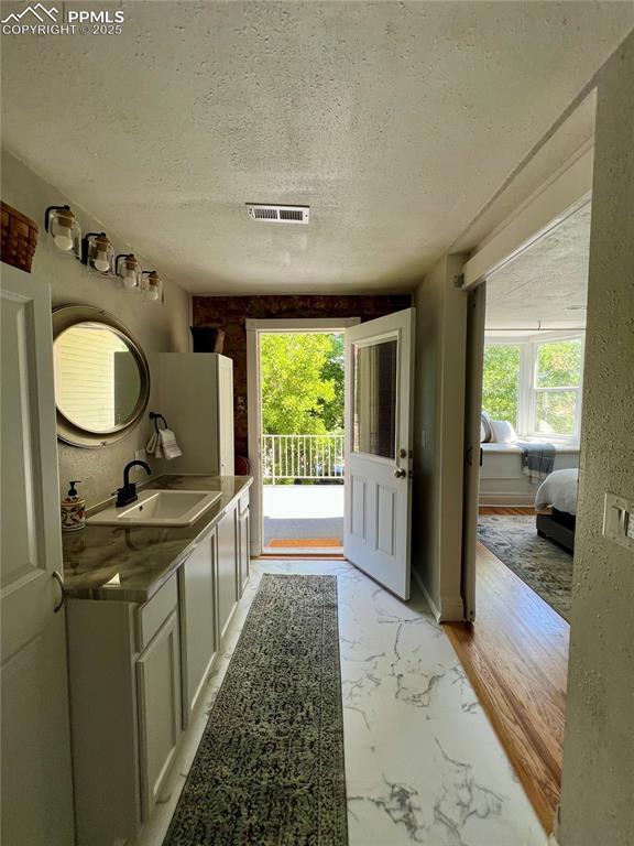313 E Evans Ave, Pueblo, CO 81004 - bathroom with a textured ceiling, vanity, and marble finish flooring