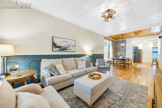 313 E Evans Ave, Pueblo, CO 81004 - living area with hardwood / wood-style floors, a wainscoted wall, and ornamental molding