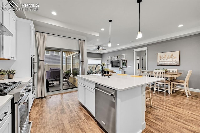 6016 Haster Grv, Colorado Springs, CO 80927 - kitchen with stainless steel appliances, a ceiling fan, a sink, a tray ceiling, and white cabinetry