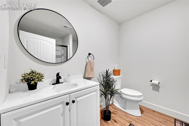 6016 Haster Grv, Colorado Springs, CO 80927 - bathroom featuring vanity, toilet, wood finished floors, and baseboards