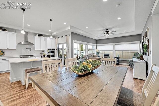 6016 Haster Grv, Colorado Springs, CO 80927 - dining room featuring light wood finished floors, recessed lighting, a ceiling fan, and a tray ceiling