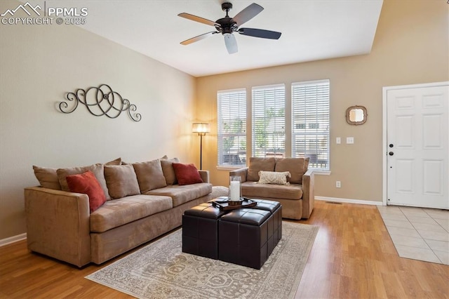 living room featuring a ceiling fan, light wood-style flooring, and baseboards