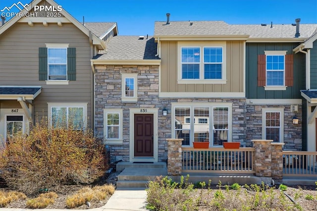 multi unit property featuring board and batten siding, stone siding, and roof with shingles