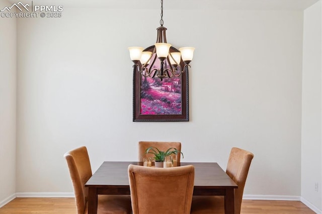 dining area with a chandelier, light wood-type flooring, and baseboards