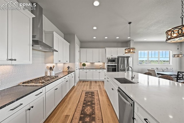 3293 Offbeaten Pl, Castle Rock, CO 80108 - kitchen featuring wall chimney range hood, appliances with stainless steel finishes, a sink, white cabinetry, and decorative backsplash