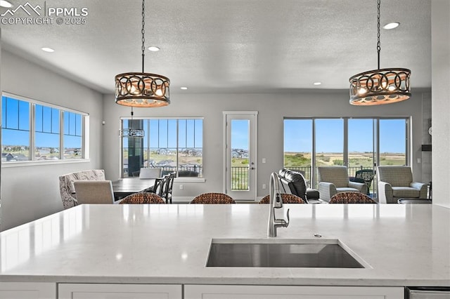 3293 Offbeaten Pl, Castle Rock, CO 80108 - kitchen with open floor plan, a sink, recessed lighting, white cabinets, and a textured ceiling