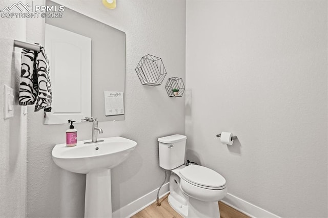 3293 Offbeaten Pl, Castle Rock, CO 80108 - half bath featuring baseboards, wood finished floors, toilet, and a sink