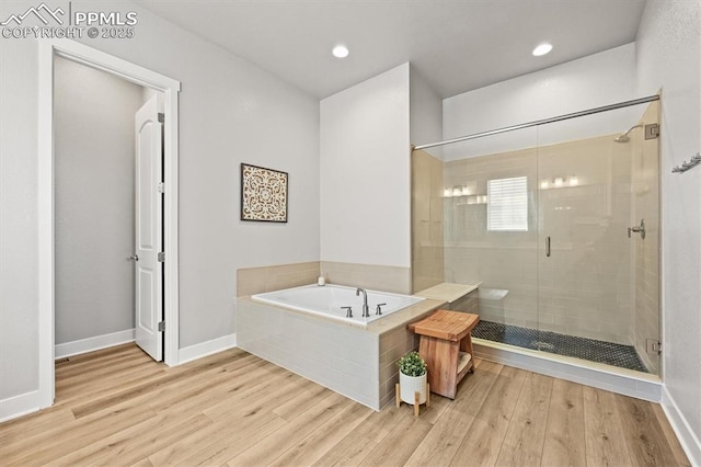 3293 Offbeaten Pl, Castle Rock, CO 80108 - bathroom with a stall shower, wood finished floors, a garden tub, baseboards, and recessed lighting