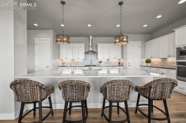 3293 Offbeaten Pl, Castle Rock, CO 80108 - kitchen featuring wall chimney exhaust hood, stainless steel appliances, backsplash, recessed lighting, and a chandelier