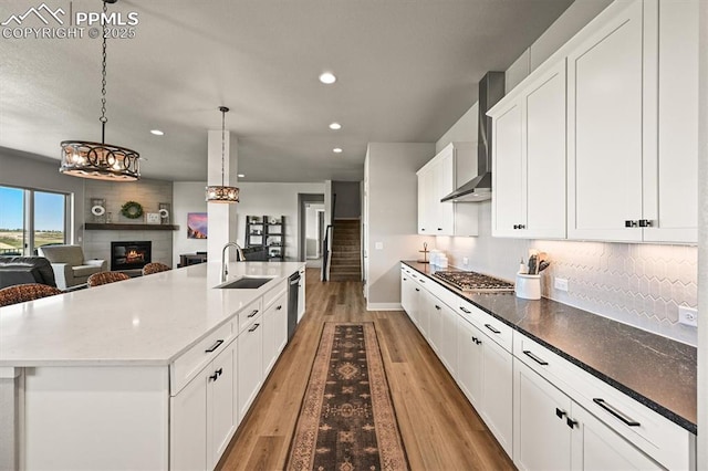 3293 Offbeaten Pl, Castle Rock, CO 80108 - kitchen featuring a sink, appliances with stainless steel finishes, a fireplace, wall chimney exhaust hood, and recessed lighting