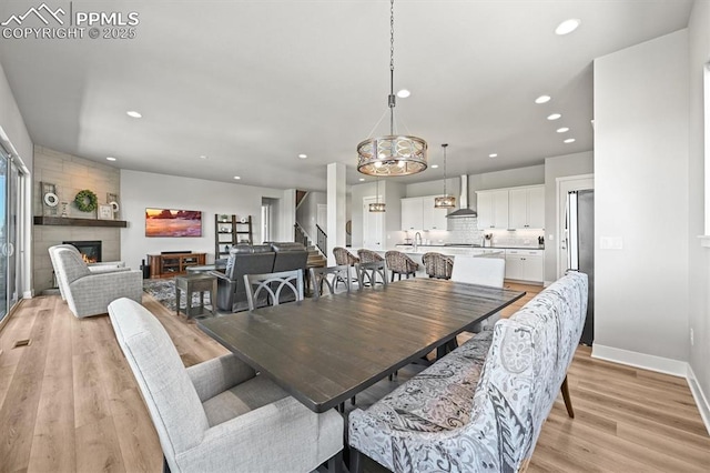 3293 Offbeaten Pl, Castle Rock, CO 80108 - dining space featuring recessed lighting, a fireplace, light wood finished floors, stairway, and baseboards