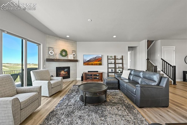 3293 Offbeaten Pl, Castle Rock, CO 80108 - living area with light wood-style flooring, a tile fireplace, stairs, and recessed lighting