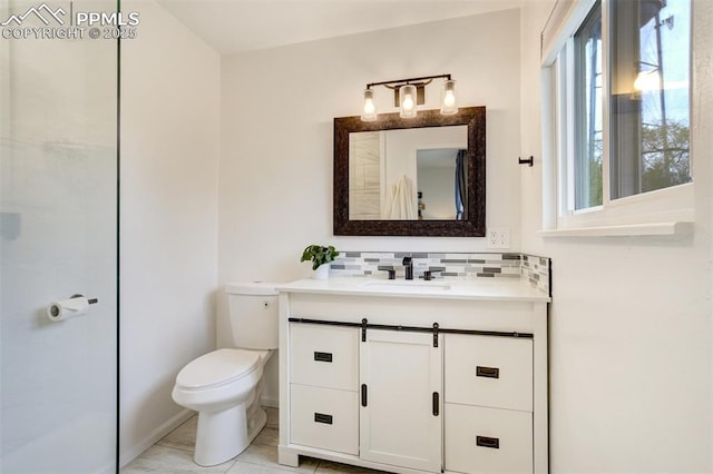 bathroom featuring toilet, backsplash, and vanity