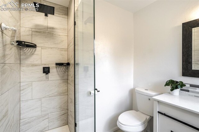 full bathroom with a shower stall, toilet, and vanity
