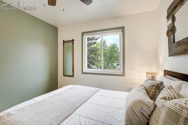 bedroom featuring a barn door and ceiling fan