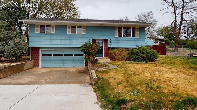 4012 Maxwell Pl, Colorado Springs, CO 80909 - raised ranch with concrete driveway, an attached garage, and brick siding