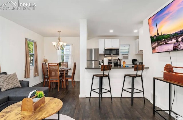 739 S Utica St, Denver, CO 80219 - living room with a chandelier, dark wood-style floors, recessed lighting, and baseboards