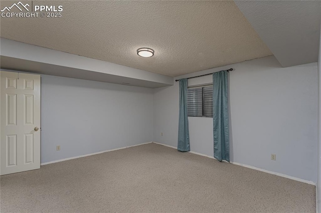 finished below grade area featuring carpet flooring, a textured ceiling, and baseboards