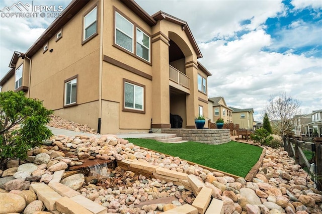 6898 Sedgerock Ln, Colorado Springs, CO 80927 - rear view of property featuring stucco siding and a balcony