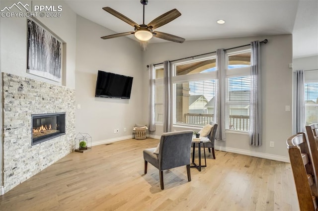 6898 Sedgerock Ln, Colorado Springs, CO 80927 - sitting room with vaulted ceiling, light wood-style floors, ceiling fan, baseboards, and a stone fireplace