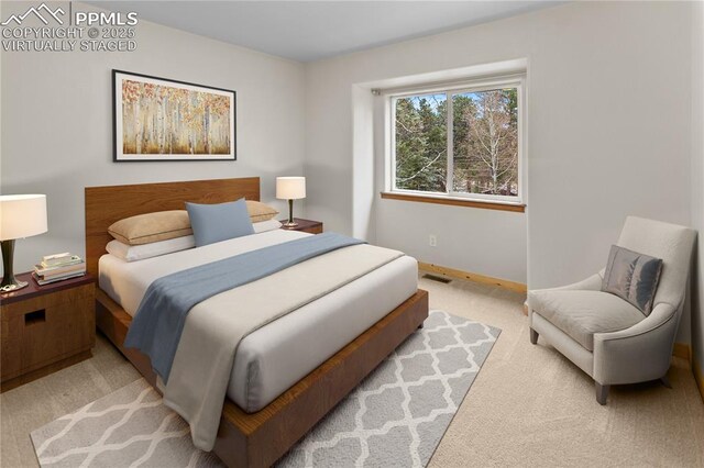 bedroom featuring light colored carpet and baseboards
