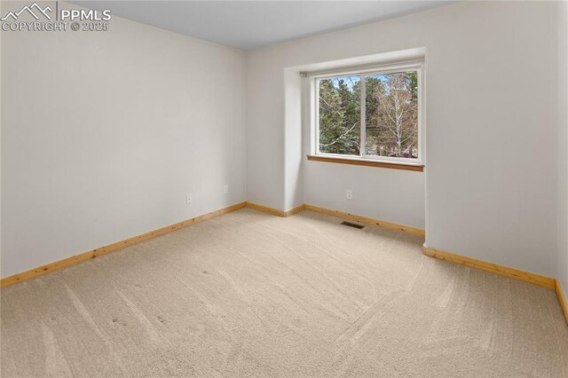 unfurnished room with carpet floors and baseboards
