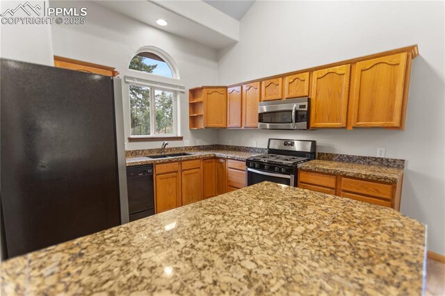 kitchen with appliances with stainless steel finishes, a sink, a towering ceiling, brown cabinetry, and open shelves