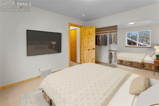 bedroom featuring light colored carpet, baseboards, and a closet