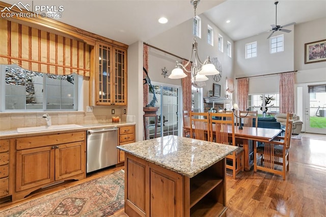 kitchen featuring a sink, dishwasher, open shelves, light wood-type flooring, and glass insert cabinets