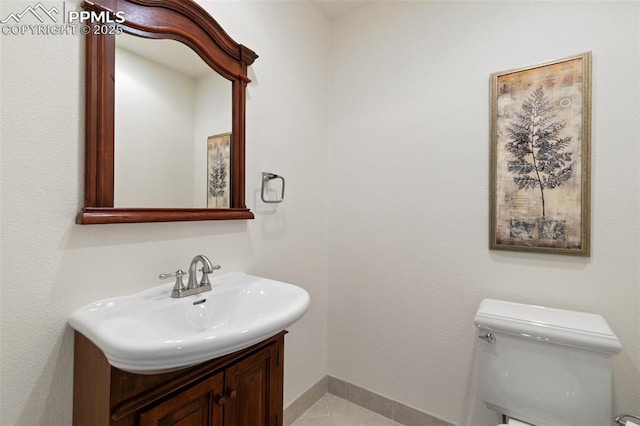 bathroom featuring tile patterned flooring, vanity, toilet, and baseboards